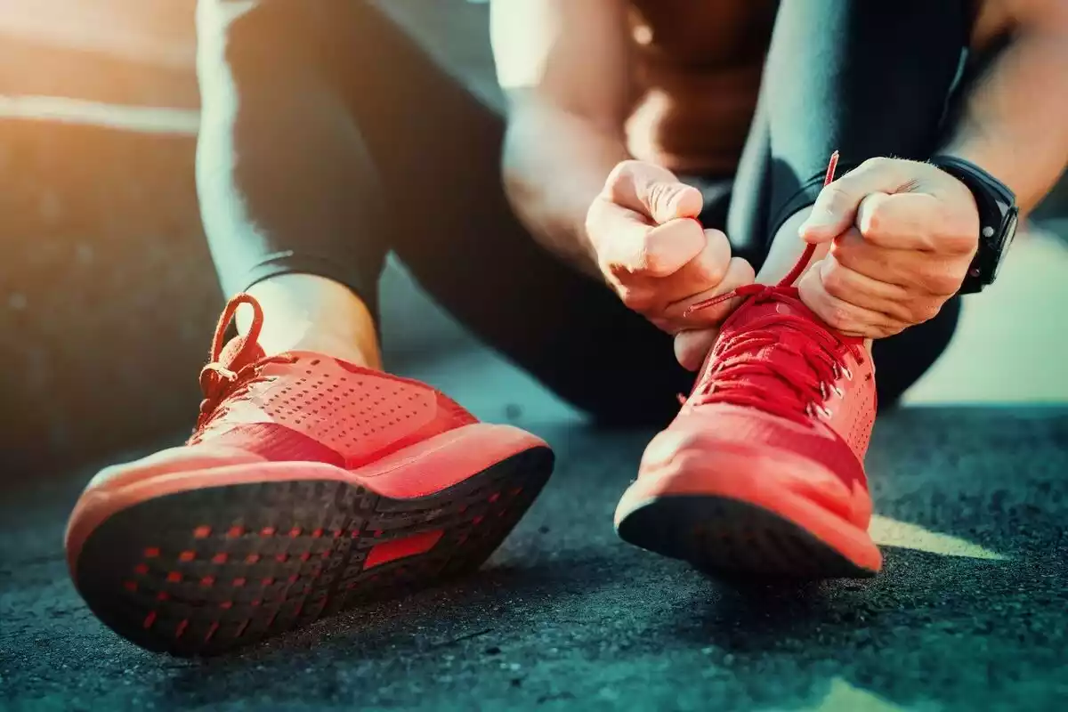 Persona atándose los cordones tras hacer deporte