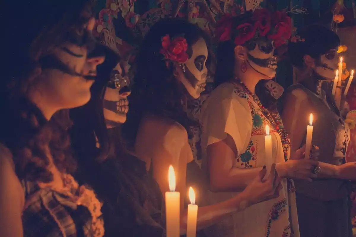 Personas con ropa tradicional mexicana celebrando el Día de Muertos