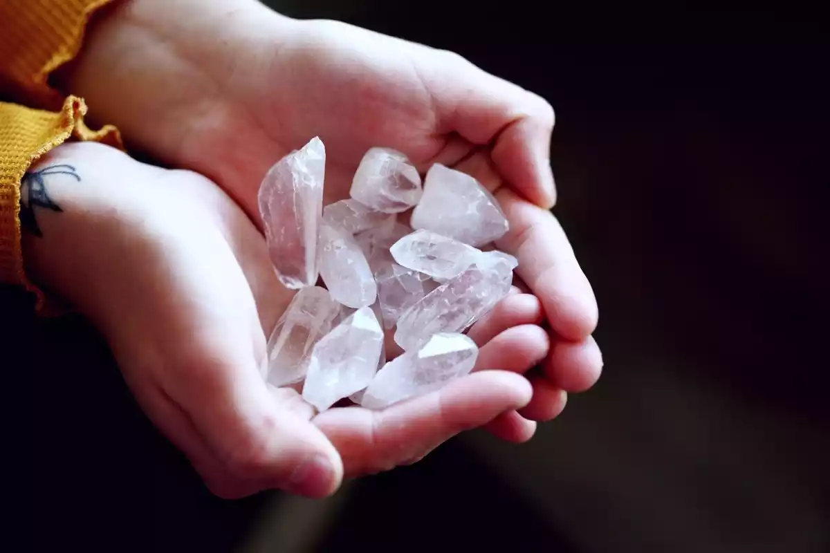 Fotografía de una mano con piedras preciosas