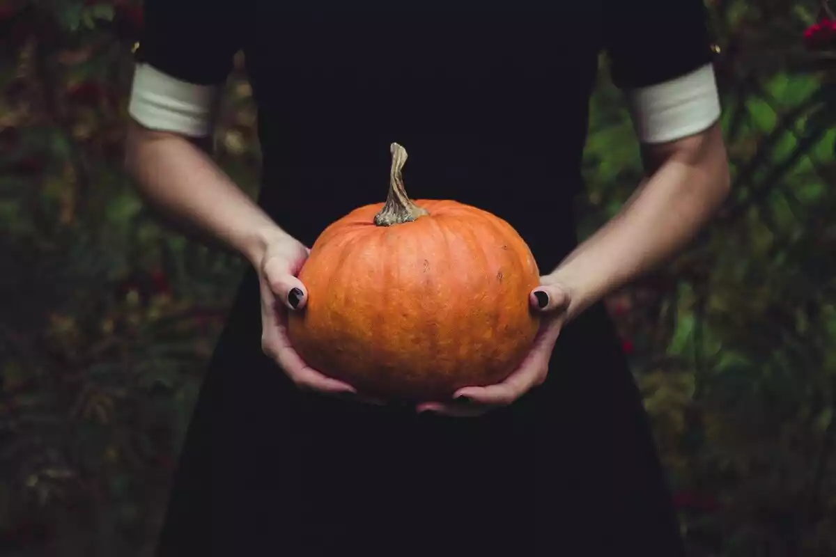 Fotografía de una mujer sosteniendo una calabaza