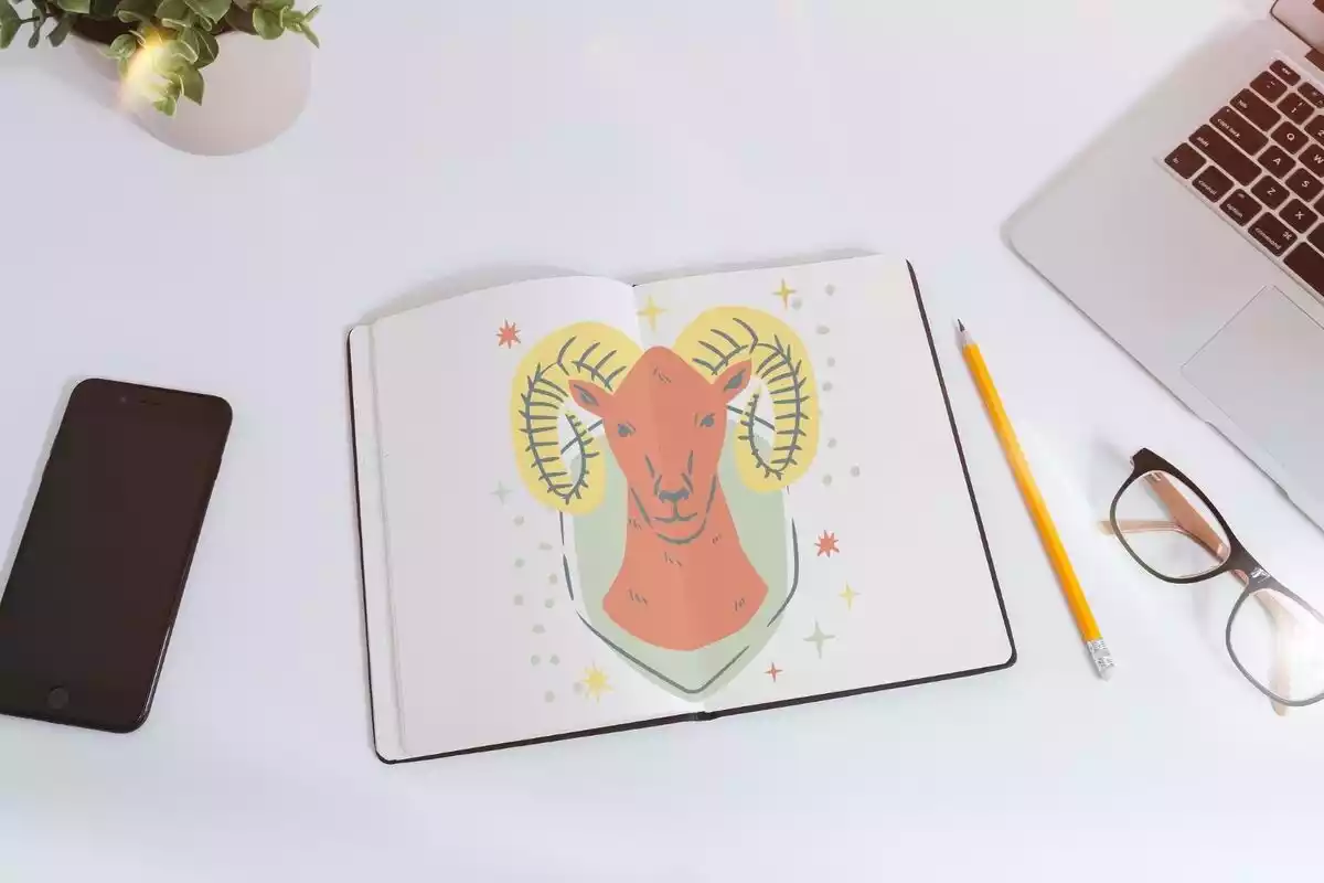 Imagen de una mesa de escritorio con fondo blanco en el centro un libro abierto y el logo de Aries en el centro