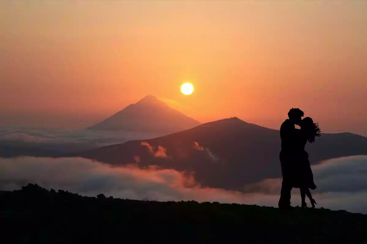 Pareja besándose en la montaña