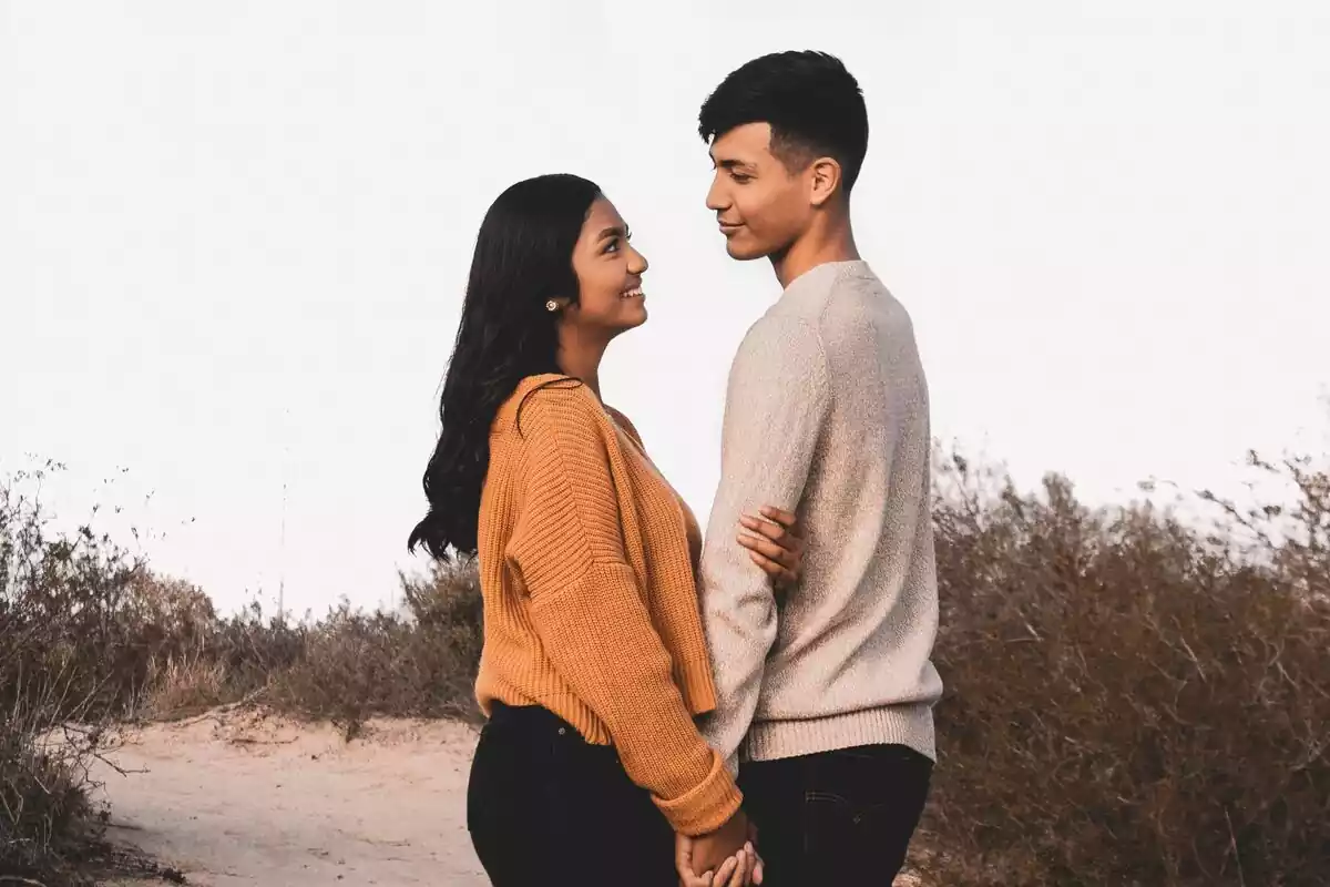 Un chico y una chica mirándose a los ojos, ambos sonrientes