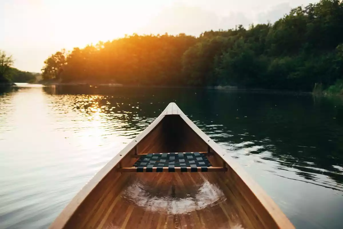 Canoa en río navegando al atardecer