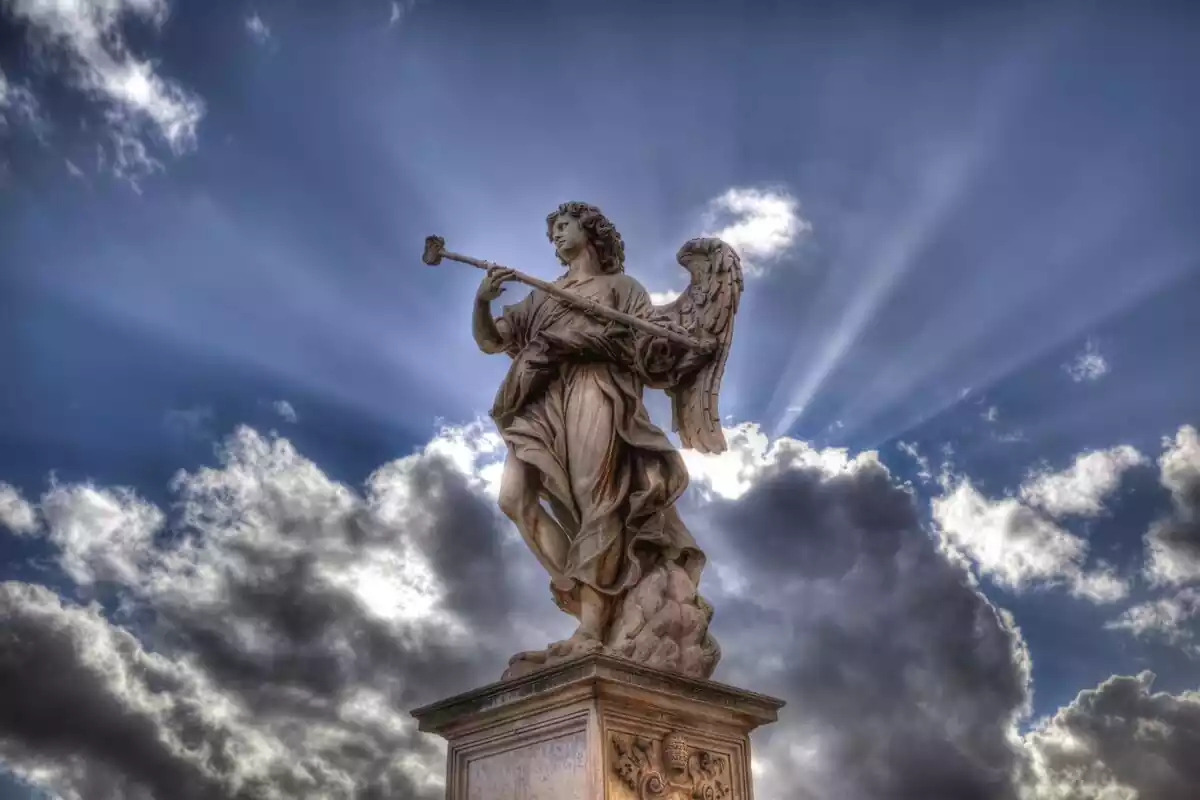 Estatua de un ángel con el cielo radiante de fondo