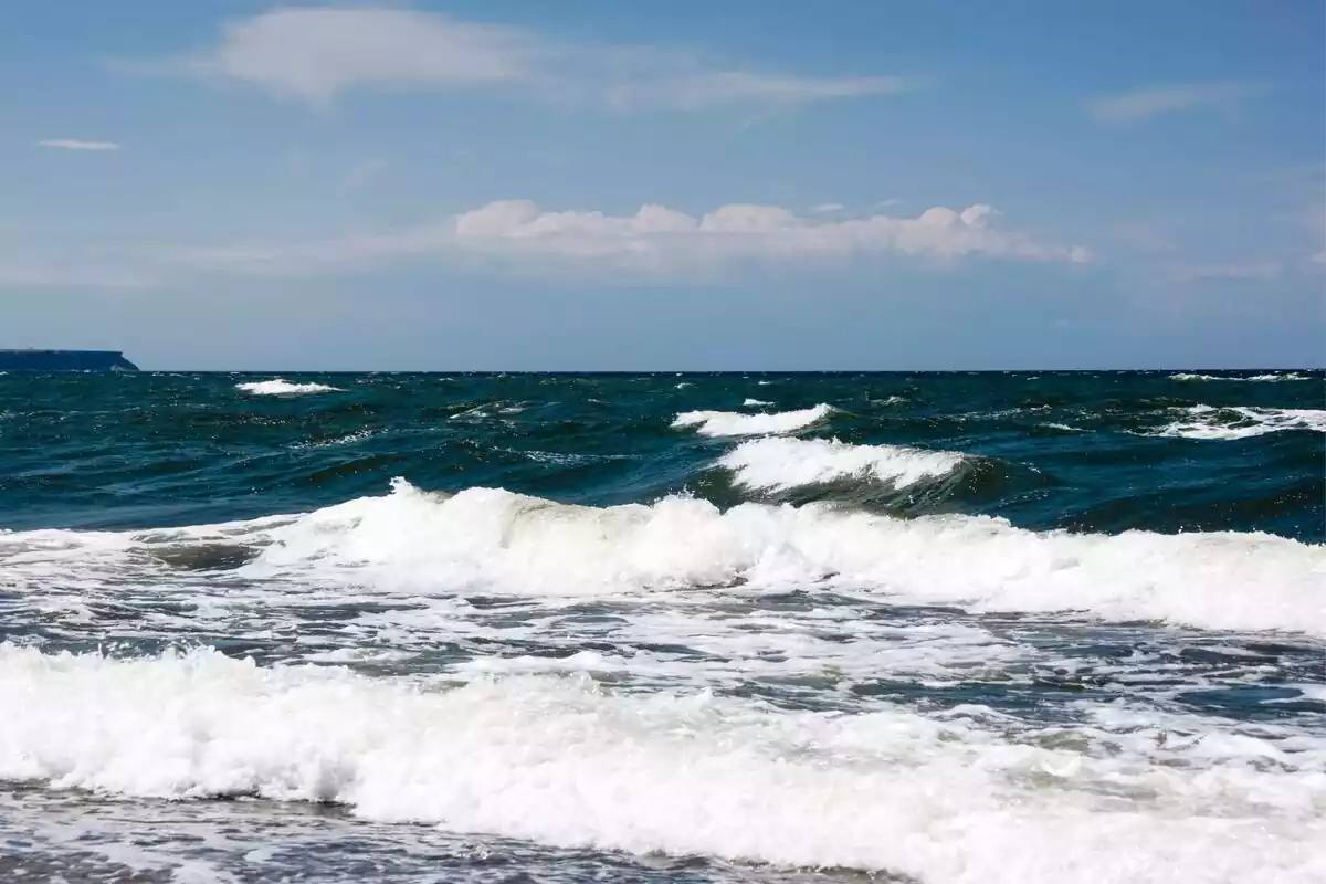 Imagen de un mar muy agitado con un cielo azul de fondo