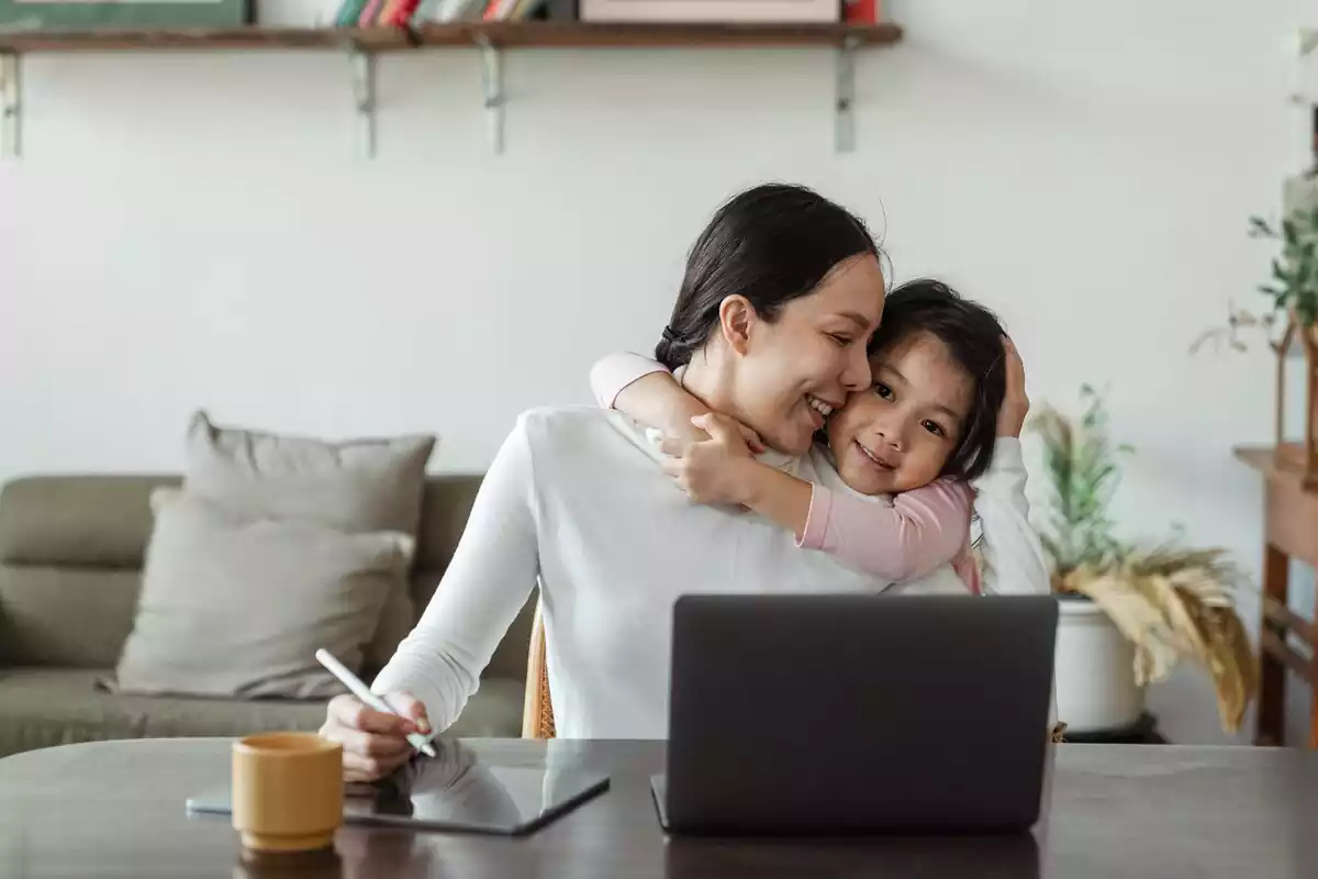 Niña pequeña abraza a mujer adulta en casa