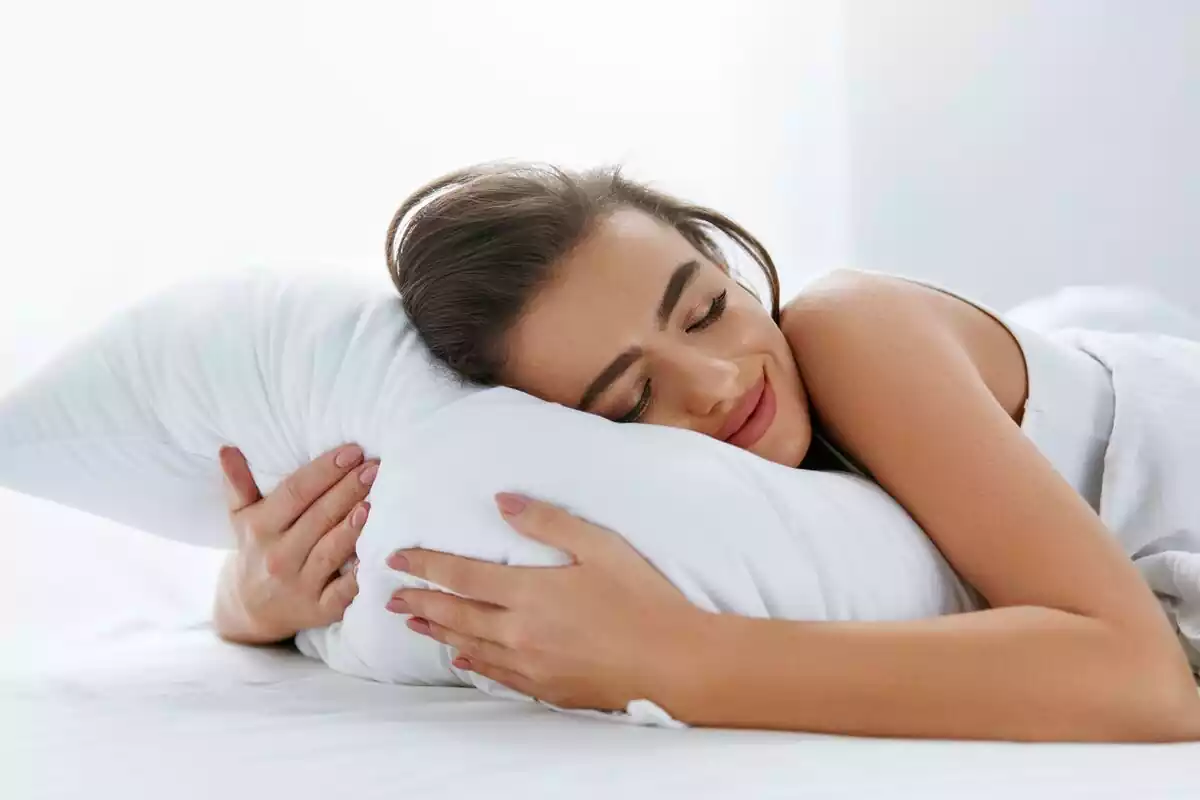 Una chica tumbada sobre una almohada sonriente