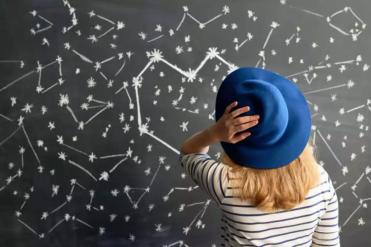 Chica en medio de una pared con estrellas dibujadas