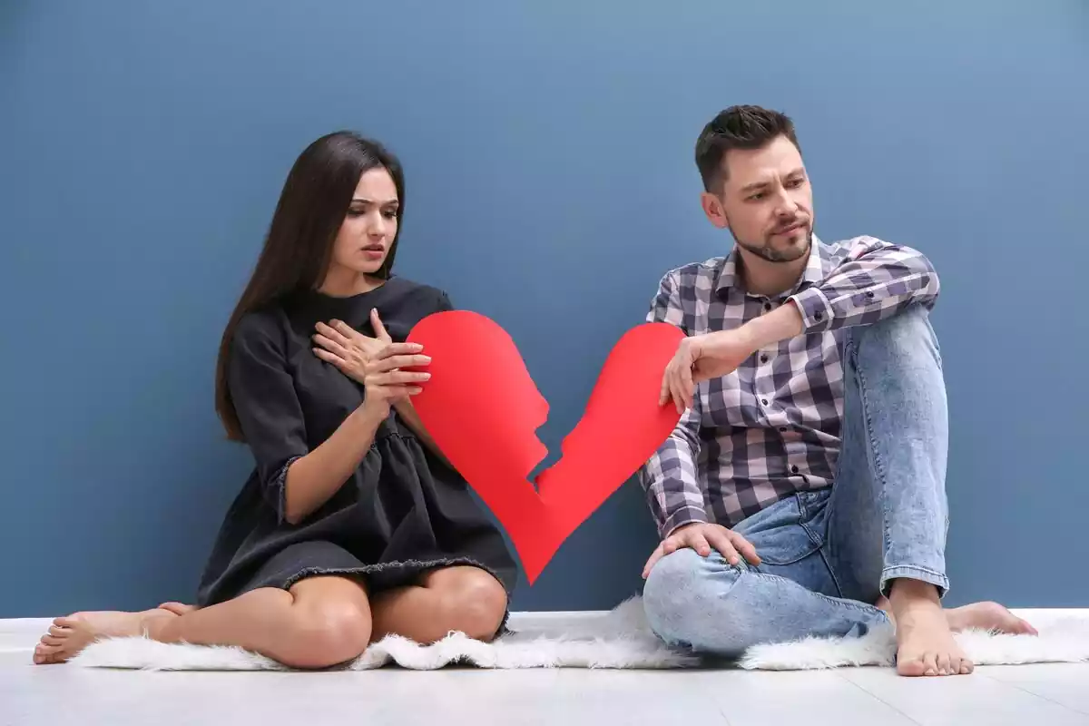 Pareja rompiendo con un corazón de papel roto