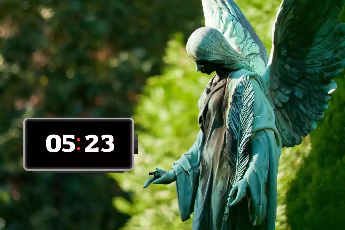 Estatua de un ángel con un marcador al lado y la hora 05:23