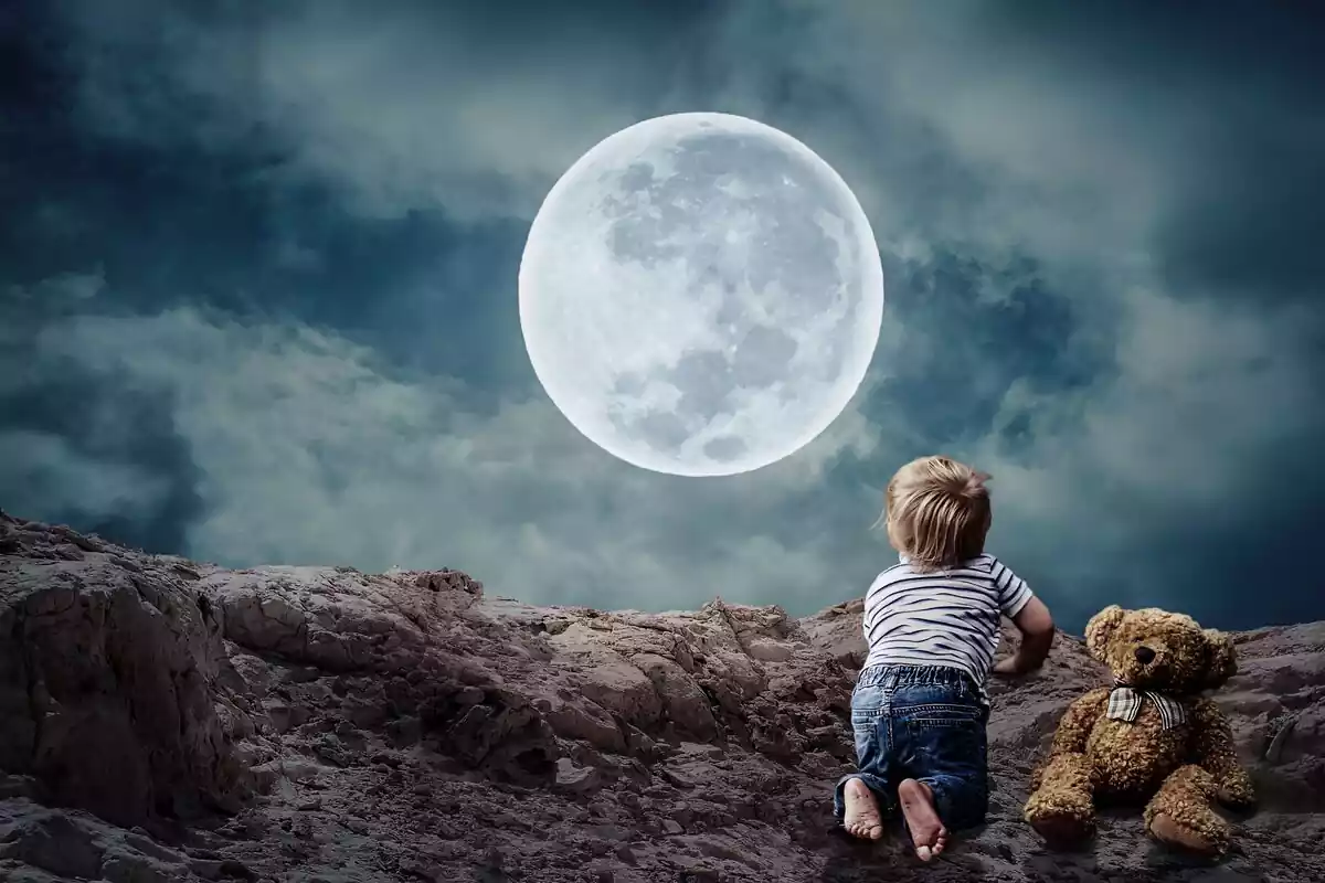 Fotomontaje de un niño mirando la luna llena junto a su oso de peluche