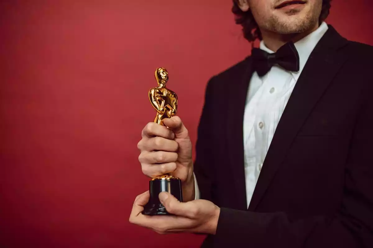 Las manos de un actor sujetando un premio