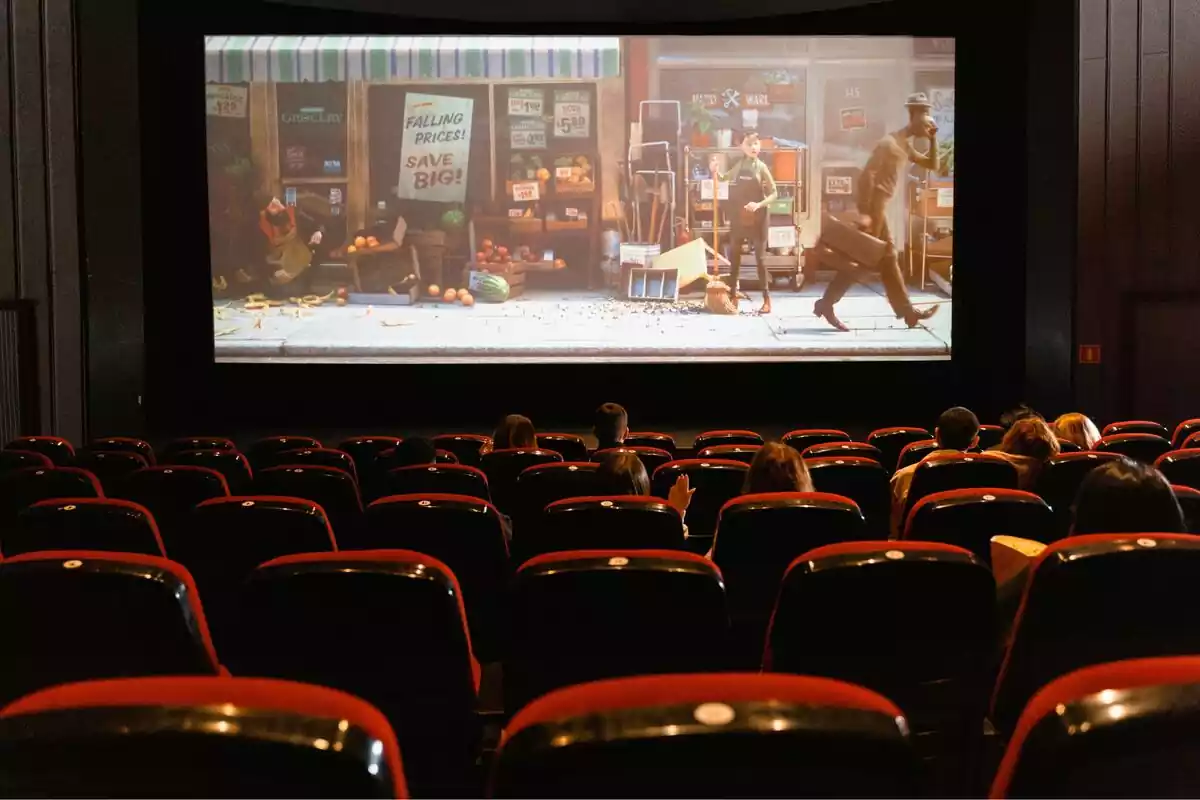 Plano general de una sala de cine con personas mirando una película de dibujos