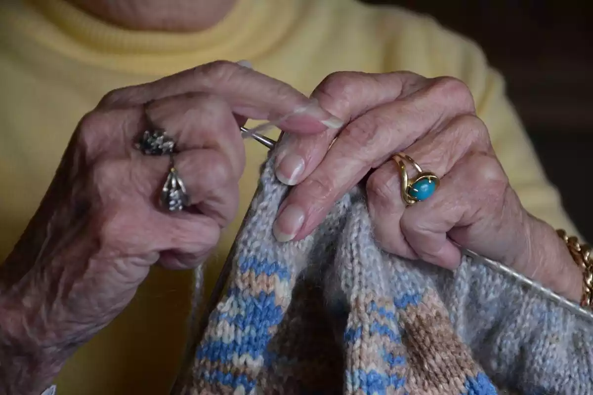 Primer plano de las manos de una abuela tejiendo