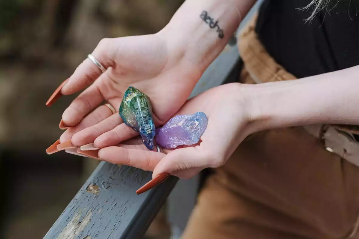 Primer plano de las manos de una chica y en sus manos la piedra ópalo