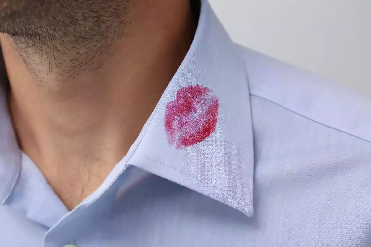 Primer plano de una camisa manchada por unos labios de pintalabios