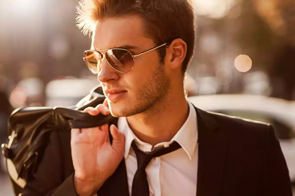 Un chico joven con gafas y una mochila en la mano