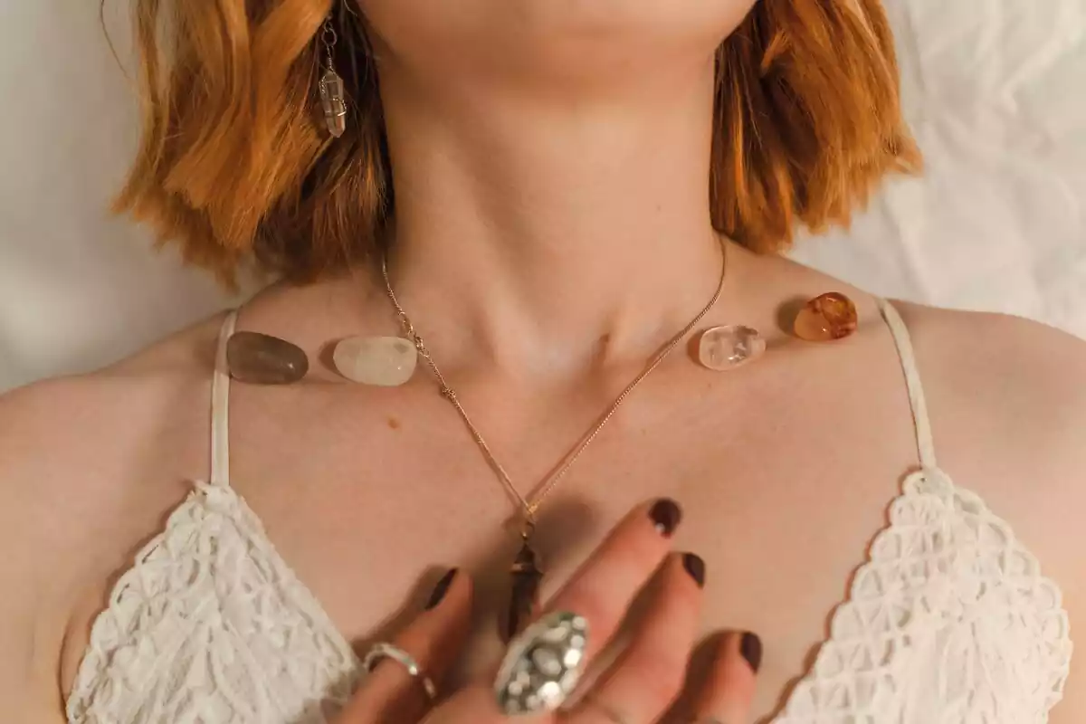 Una chica con una piedra como collar y varias piedras en el cuello