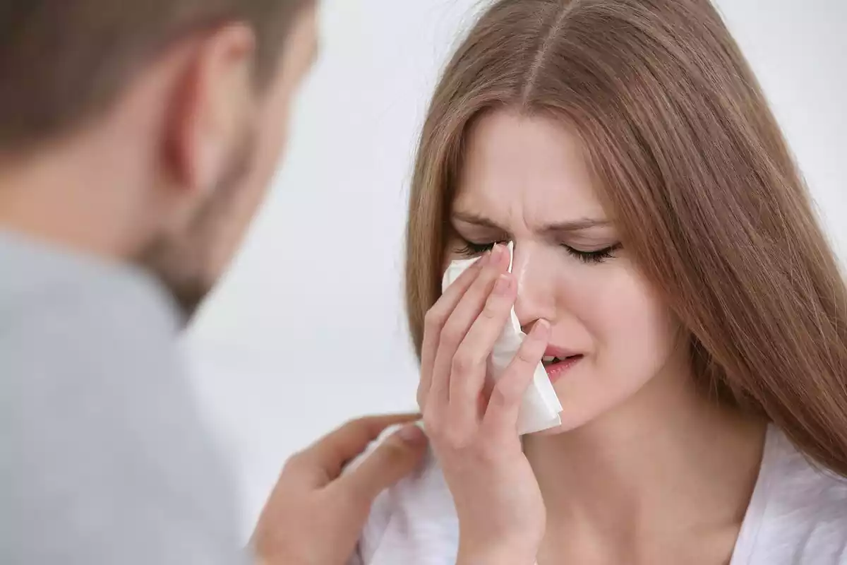 Una chica llorando y su pareja consolándola