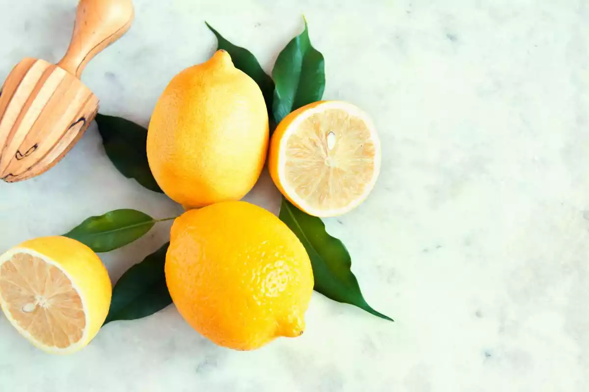 Primer plano de dos limones enteros y uno cortado