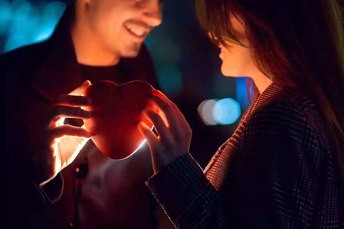 Una pareja sujetando un corazón